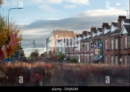 I fan del Manchester United Football Club a piedi verso il basso Sir Matt Busby Way avvicinando lo stadio Old Trafford (solo uso editoriale) Foto Stock