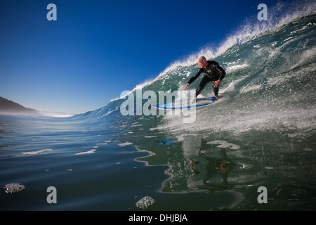 Un surfista cavalca un inverno wave a Torrey Pines State Beach, San Diego, California. Foto Stock