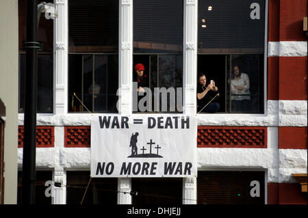 Un banner antiwar pende da un edificio durante il Giorno del Ricordo cerimonie in Piazza della Vittoria nel centro cittadino di Vancouver, British Columbia, Canada Foto Stock