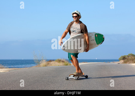 Ragazzo pattinaggio con il cappello e la sua tavola da surf Foto Stock