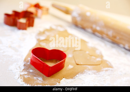 La cottura a forma di cuore ad gingerbread cookies per Natale. Foto Stock