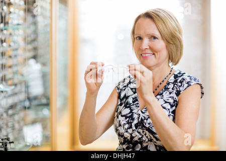 Donna cerca su vetri a ottico Store Foto Stock