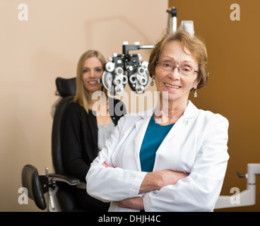 All'ottico optometrista femmina con paziente in background Foto Stock