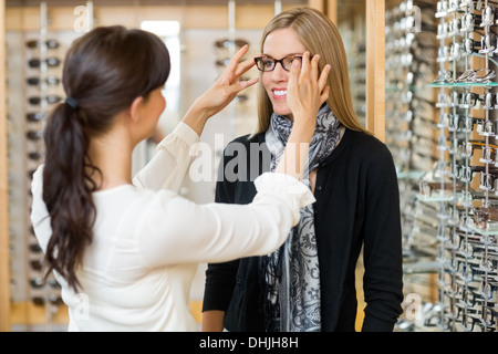 Commessa assistendo il cliente al con gli occhiali Foto Stock