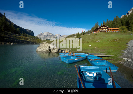 Barche a remi e guesthouse al lago Oeschinensee, Kandersteg, Oberland bernese, il Cantone di Berna, Svizzera, Europa Foto Stock