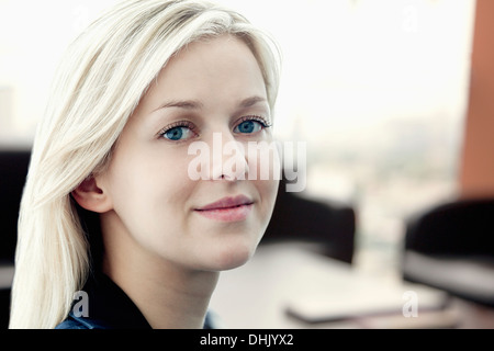 Ritratto di giovane imprenditrice sorridente con i colleghi di lavoro in background Foto Stock