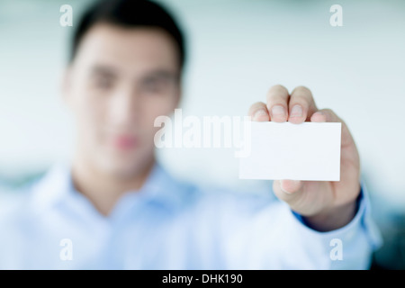 Giovane imprenditore tenendo business card per la fotocamera Foto Stock