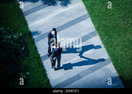 Vista aerea di due imprenditori stringono le mani sul marciapiede Foto Stock