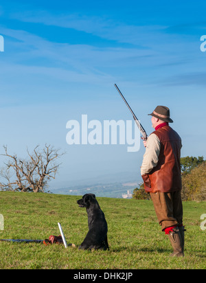 Un uomo con un colpo di pistola sorgeva su un fagiano sparare in attesa per l'inizio della giornata di riprese Foto Stock