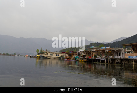 Linea di case galleggianti lungo la riva del lago Dal a Srinagar in Kashmir, India, con shikaras (piccole e strette barche in legno) Foto Stock