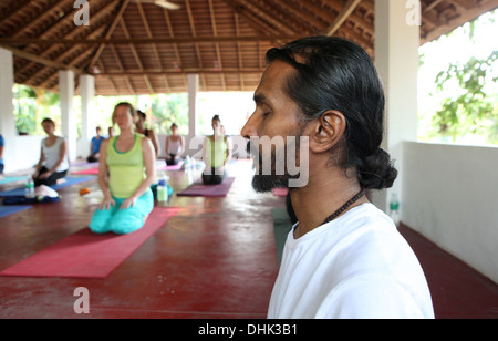 Insegnante di Yoga meditazione con i suoi allievi in Varkala,l'India. Foto Stock