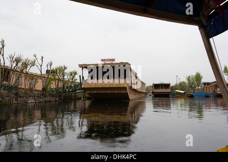 Vista della casa galleggiante da una shikara in la dal lago. Ci sono un gran numero di tale fermo barche in legno di catering per i turisti. Foto Stock