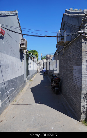 Uomo che cammina verso il basso un hutong di Pechino, Cina Foto Stock