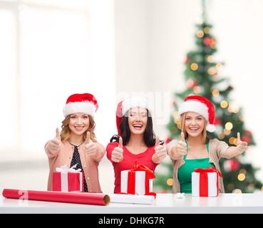 Donna sorridente in santa helper cappelli con confezioni regalo Foto Stock