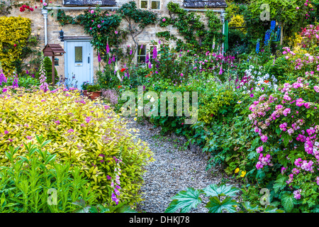 Un grazioso cottage Inglese giardino nel villaggio Costwold di Bibury in estate. Foto Stock