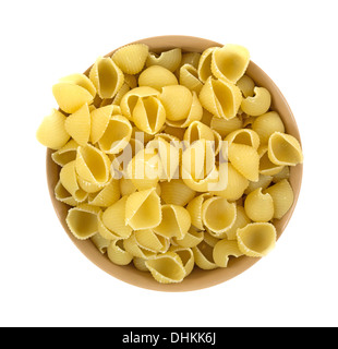 Vista dall'alto di un tan ciotola riempita con piccole conchiglie di pasta su uno sfondo bianco. Foto Stock