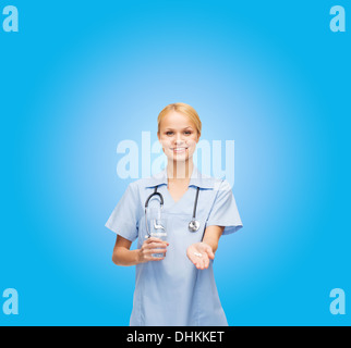 Sorridente medico o infermiere offrendo pillole e acqua Foto Stock