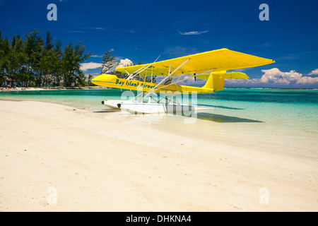 Giallo float plane parcheggiata su una spiaggia tropicale. Roatan, Honduras Foto Stock