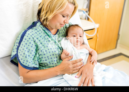 Donna che guarda Babygirl sul letto di ospedale Foto Stock