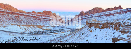 Interstate 70 avvolge il modo attraverso la coperta di neve Spotted Wolf Canyon attraverso il San Rafael Reef in Utah in inverno (Panorama) Foto Stock