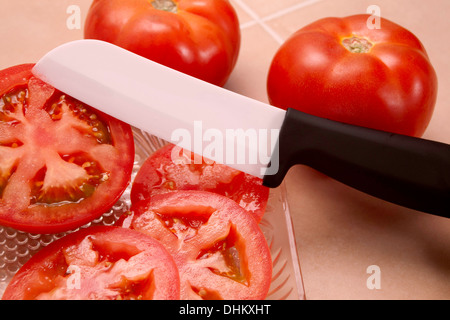 Giardino pomodoro fresco tagliato con un molto affilata lama in ceramica. Foto Stock