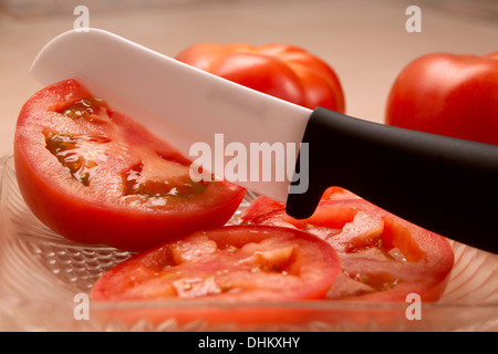 Giardino pomodoro fresco tagliato con un molto affilata lama in ceramica. Foto Stock