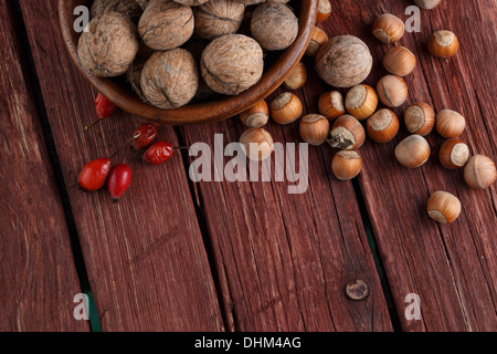 Le noci e le nocciole su rustiche in legno scuro dello sfondo Foto Stock