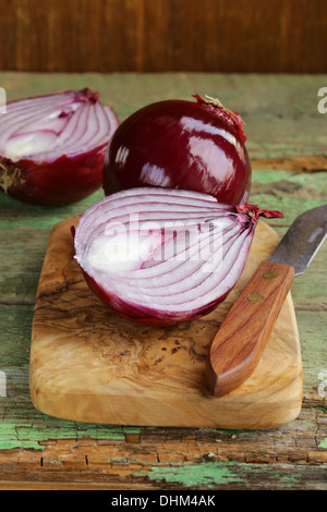 Dolce cipolle rosse su un tagliere di legno Foto Stock