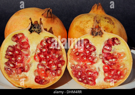 Melagrane tagliate a metà mostra frutta rossa all'interno. Foto Stock