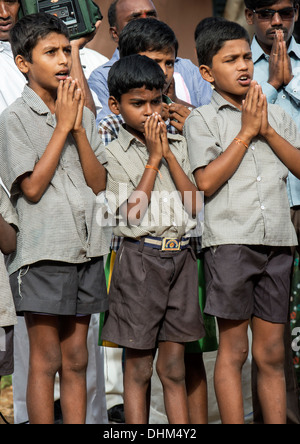 Rural Indian School ragazzi cantano canti devozionali in Sri Sathya Sai Baba outreach mobile al servizio dell'ospedale. Andhra Pradesh, India. Foto Stock