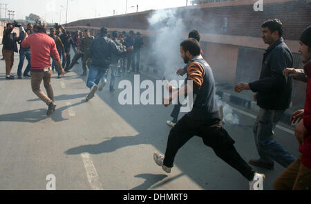 Srinagar, Indiano Kashmir amministrato del 13 novembre 2013. Kashmir musulmani sciiti correre in mezzo a un gas lacrimogeno dopo la polizia indiana ha cercato di fermarli durante un Muharram processione religiosa a Srinagar, la capitale estiva di Indiano Kashmir amministrato, India. Centinaia di mussulmano sciita lutto sono stati arrestati dalla polizia indiana come hanno cercato di prendere parte alla processione. Credito: yawar nazir kabli/Alamy Live News Foto Stock