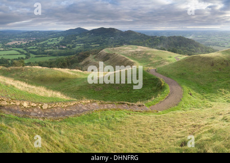 Il percorso si snoda attraverso i livelli in British Camp verso il Malvern Hills a sunrise. Foto Stock