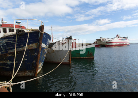 Isole di Orkney, Scozia. Barche da pesca sotto riattaccare al St Margaret's Hope Harbour con la MV Pentalina in background. Foto Stock