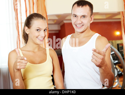 Ritratto di ragazza sportive e guy guardando la telecamera con un sorriso in palestra Foto Stock