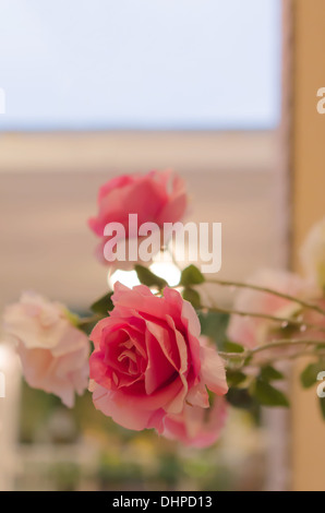 Bouquet di rose di plastica e nel vaso di ceramica Foto Stock