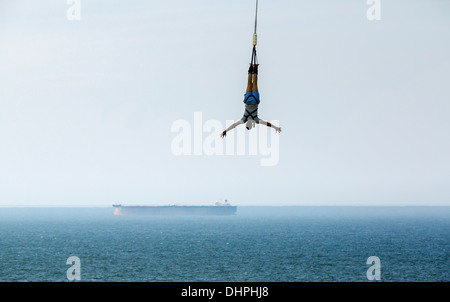 Paesi Bassi, Scheveningen, nei pressi dell'Aia. Bungee Jumping dal molo. Barca in background Foto Stock