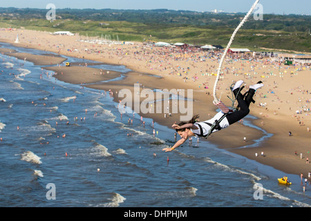 Paesi Bassi, Scheveningen, nei pressi dell'Aia. Bungee Jumping dal molo. Spiaggia affollata in background. Foto Stock