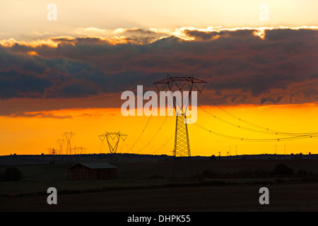 Linee elettriche ad alta tensione su Tuscanien paesaggio al tramonto, Toscana, Provincia di Viterbo, Lazio, Italia Foto Stock