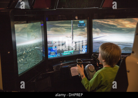 Paesi Bassi, Lelystad, Aviodrome, aviazione museo di storia. Bambino in flight simulator Foto Stock
