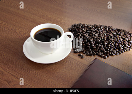 Immagine messa a fuoco il caffè nella tazza bianca e un seme è posto nelle vicinanze. Foto Stock