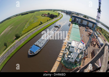Paesi Bassi, Westerbroek, General cargo presso il Ferus Smit cantiere navale. Canale chiamato Winschoterdiep. Il passaggio di navi cisterna Foto Stock