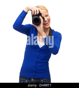 Donna sorridente di scattare una foto con la fotocamera digitale Foto Stock