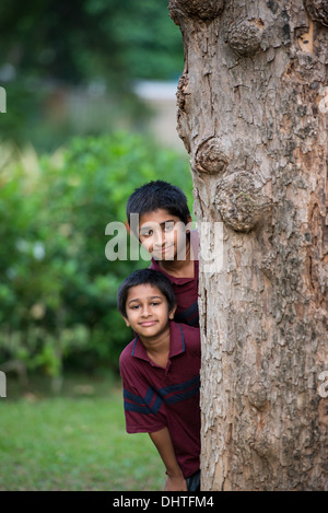 Bello toddler indiano permanente sorride all'aperto Foto Stock