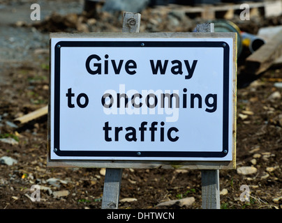 "Dare modo ai veicoli che sopraggiungono in senso contrario", segno sul sito di costruzione. Vecchio Hutton, Cumbria, England, Regno Unito, Europa. Foto Stock