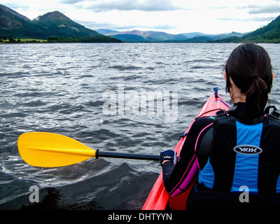 Vista posteriore del kayaker femmina caucasico sul lago con montagne in lontananza. REGNO UNITO Foto Stock