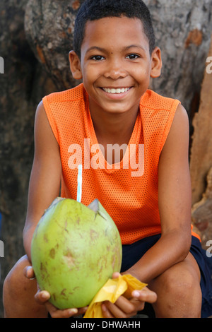Ragazzo brasiliano tenendo una noce di cocco Foto Stock
