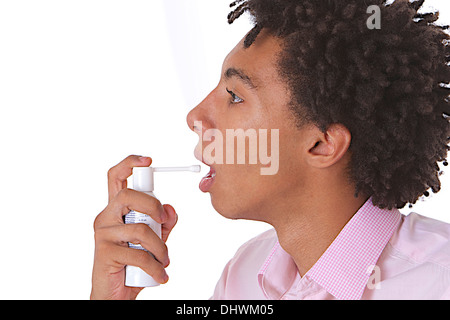 Adolescente utilizzando spray in bocca Foto Stock