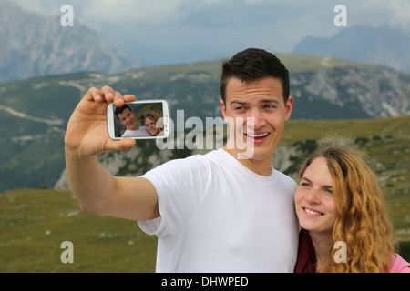 Coppia giovane a scattare foto con uno smartphone come una memoria in vacanza Foto Stock