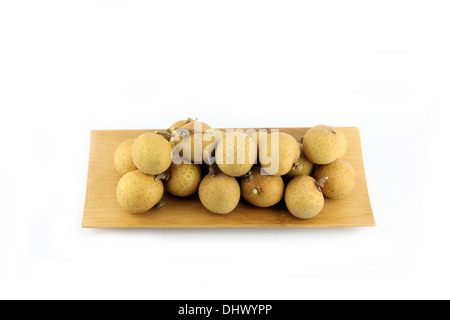 Longan di frutta in bambù piatto su uno sfondo bianco. Foto Stock