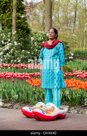 Paesi Bassi Lisse, giardini Keukenhof. Donna indiana indossando grande zoccoli per scattare la foto Foto Stock